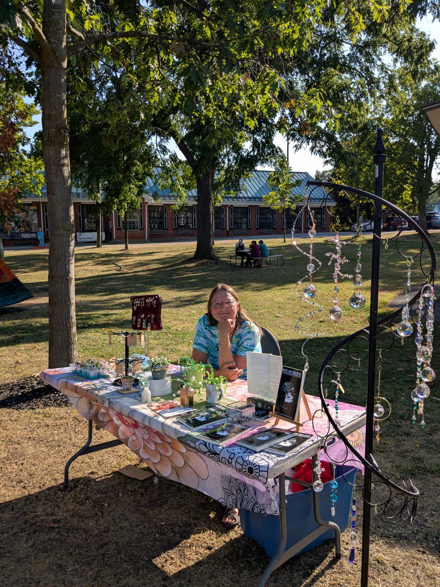 Lisa Pope at her market table with her book and handmade work